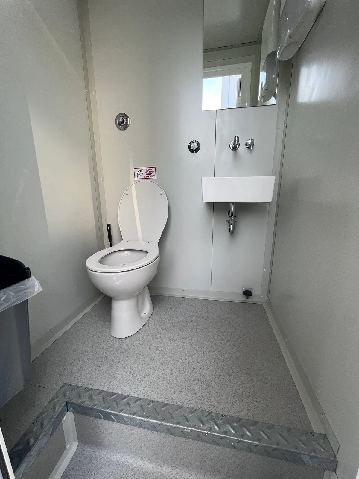 Εσωτερικό Saronis με WC, ορθογώνιο νιπτήρα και καθρέπτη.